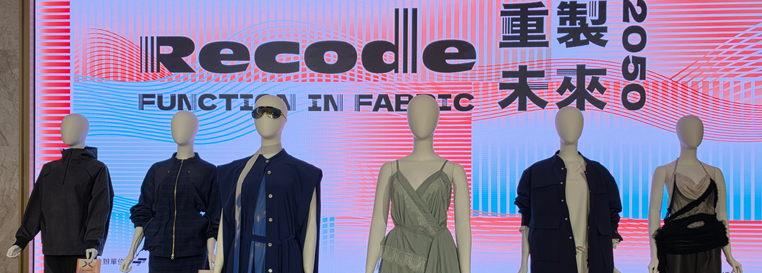 Outfits from the RECODE 2050 fashion show at TITAS displayed on mannequins in front of the Function in Fabric backdrop